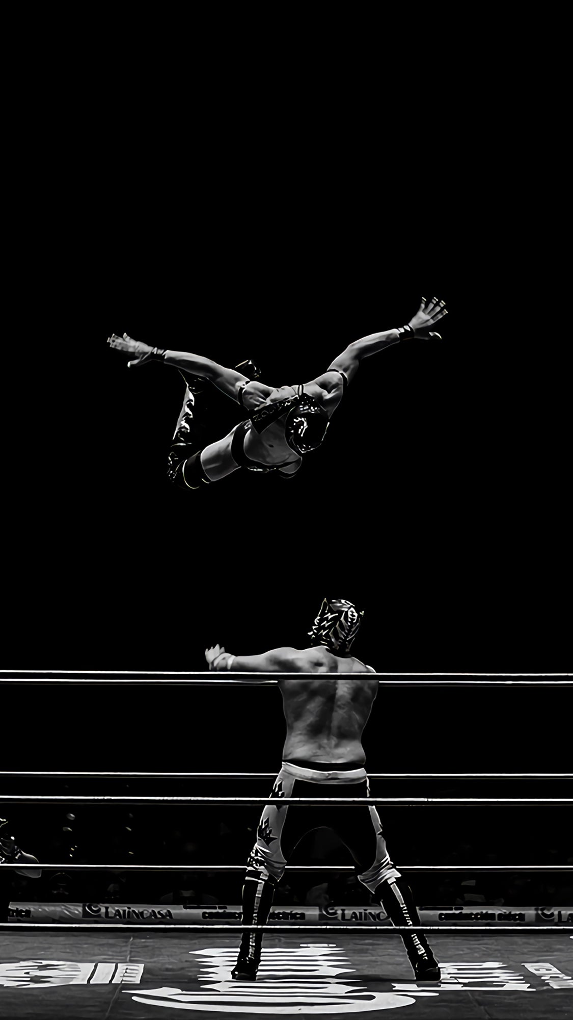 Two Luchadores With One Flying Off Ropes at the Other