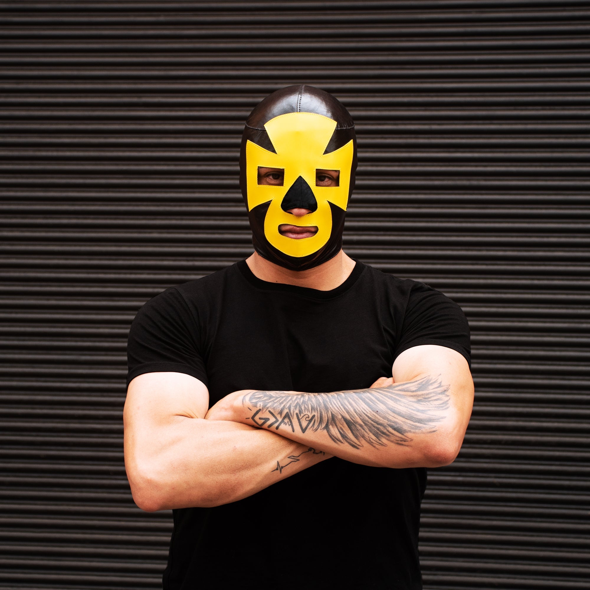 Man wearing black & yellow luchador wrestling mask